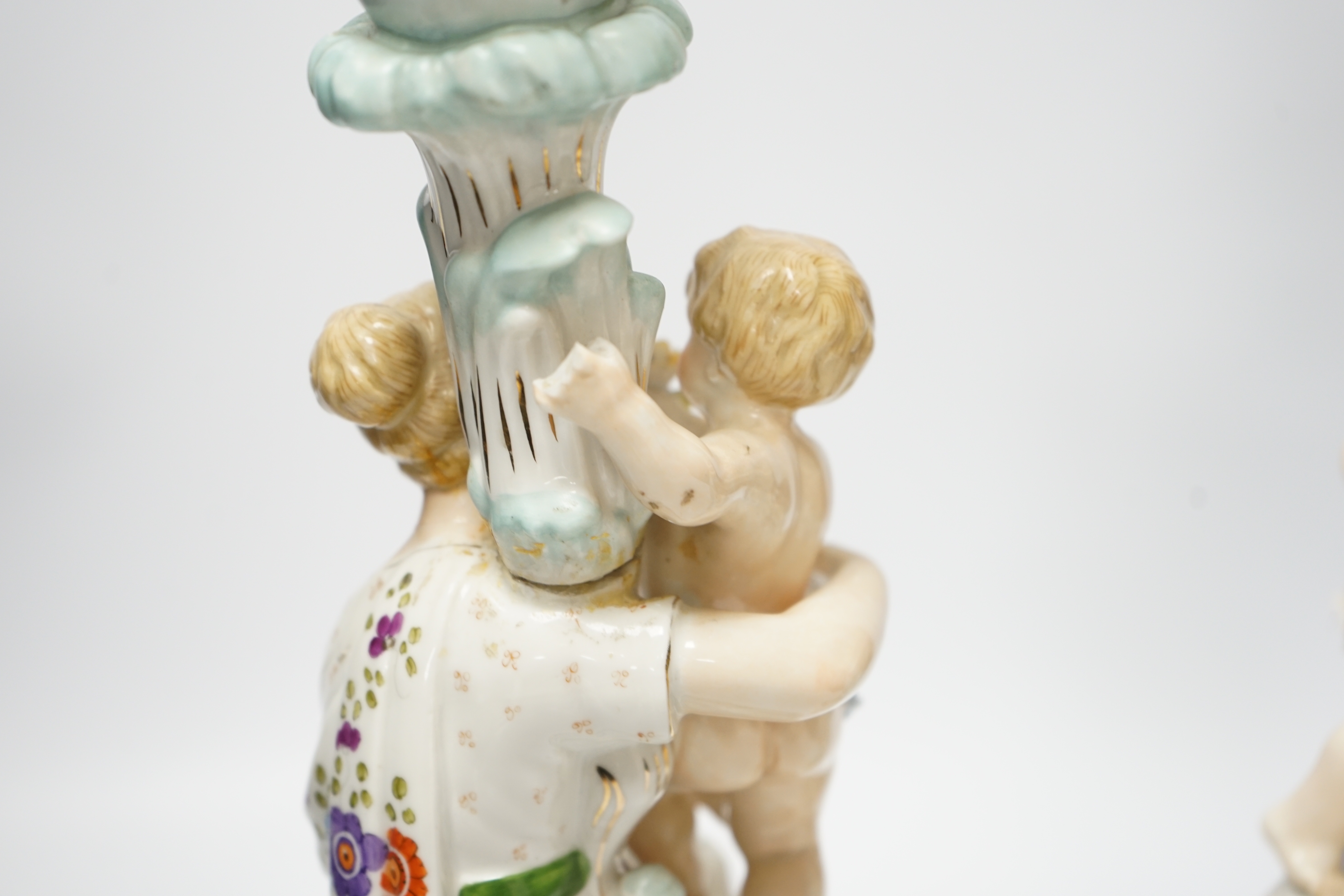 A pair of German floral encrusted porcelain candlesticks of a mother and child group, 38cm high